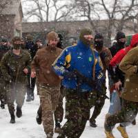 Fighters of Ukrainian volunteers Azov battalion do morning exercises on Feb. 9, on their base in the southern Ukrainian city of Mariupol. Croatian volunteers fighting alongside Ukrainian army; Serb counterparts helping pro-Russian rebels