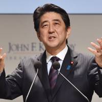 Prime Minister Shinzo Abe gestures as he delivers a speech at an international symposium held in Tokyo on March 18. Cabinet OKs tax breaks for firms to move headquarters from Tokyo