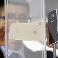 A man looks at a Samsung S6 during the opening day of the 2015 Mobile World Congress (MWC) in Barcelona, Spain, on Monday. Phone makers will seek to seduce new buyers with even smarter Internet-connected watches and other wireless gadgets as they wrestle for dominance at the world’s biggest mobile fair. Samsung unveils sleek new Galaxy phones to battle Apple
