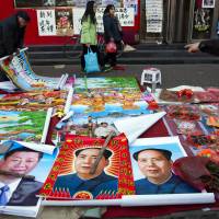 Vendors sell posters of Chinese President Xi Jinping and late leader Mao Zedong on a street of Gujiao in northern China’s Shanxi province last month. As Chinese party leader, Xi defies expectations