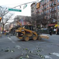 Flowers are scattered on the ground Sunday across the street from the site of an apparent gas explosion that took place three days earlier in the East Village neighborhood of New York. Rescue workers Sunday found a second body in the rubble. Police: Second body found three days after NYC building gas blast