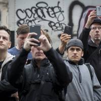 People look at the site of an apartment building that had collapsed and was engulfed in flames in New York City's East Village neighborhood on Thursday following a gas explosion. Twenty-two people were injured in the accident. Citizen journalism given a boost