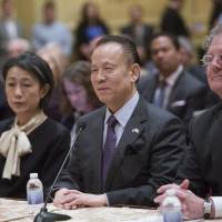 Japanese billionaire Kazuo Okada (center) smiles Thursday before the Mississippi Gaming Commission in Biloxi, Mississippi. The regulator renewed the license of gaming magnate Okada to operate in the state, saying it based the decision on its own investigation and not on press reports about allegations of bribery in the Philippines. Japan's tax agency, Hong Kong join FBI in scrutinizing casino developer