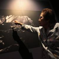 Yoshiko Shimabukuro, who was a member of the Himeyuri student nurse corps 70 years ago, points to a photo of the First Surgical Cave where she was stationed during the battle of Okinawa. She is pictured at Himeyuri Peace Museum in Itoman, Okinawa Prefecture, on March 22. Iwo Jima vet, Okinawa survivor wrestle with WWII legacy
