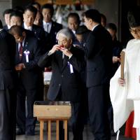 Diet members, including ruling Liberal Democratic Party lawmaker Hidehisa Otsuji (center) drink sacred sake after paying their respects to the war dead at Yasukuni Shrine in Tokyo on Wednesday. Prime Minister Shinzo Abe sent a ritual offering on Tuesday, irking Asian neighbors just before he hopes to meet Chinese President Xi Jinping on the sidelines of a leaders’ summit in Jakarta. 106 Diet members visit Yasukuni Shrine, prompting criticism from South Korea