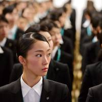 Not a chapatsu in the place: New recruits for Seven & I Holdings Co. attend an initiation ceremony in Tokyo, with nary a lighter-hued hair in sight. April marks the start of many young people's working lives in Japan. April: the season of newbies, <em>nendo</em> and <em>Narita taishoku</em>
