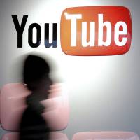 Major player: A woman walks past the YouTube logo at the company’s Tokyo office. Spotify, Pandora help slow decline in record sales
