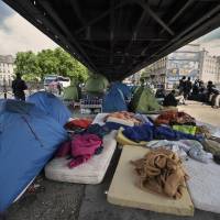 Hundreds of migrants, mostly from East Africa, live in this camp, some for a year, under the elevated railway near the Porte de la Chapelle in Paris on Tuesday. U.N. Secretary-General Ban Ki-moon said Tuesday the EU must do more to help migrants flooding in from across the Mediterranean. Ban tells Europe to offer more help to migrants crossing Mediterranean
