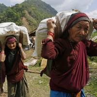 Elderly villagers carrying international relief aid start their 20-km hike home from the Nepalese village of Balua on Thursday. Days after quake, aid arrives in remote Nepal villages