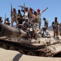 Anti-Houthi fighters of the Southern Popular Resistance stand on a tank in Yemen's southern port city of Aden on Sunday. The Houthis have agreed to a Saudi-proposed truce starting Tuesday. Saudi-proposed five-day truce starting Tuesday in Yemen gets conditional Houthi nod