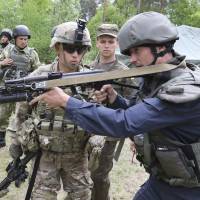An American sergeant instructs a Ukrainian soldier during joint training exercises on a military base in western Ukraine’s Lviv region on May 14. To Russia's annoyance, U.S. hones Ukrainian fighting skills