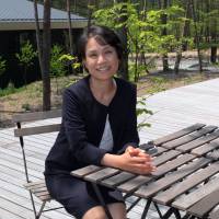 Lin Kobayashi, founder and chair of the board of International School of Asia, Karuizawa, sits at a table on the patio at the school in Nagano Prefecture following an interview with The Japan Times on May 15. Karuizawa boarding school touts international diversity, hard truths