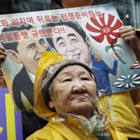 Former “comfort woman” Kil Un-ock, who was forced to serve as a prosititue for the Japanese troops during the war, attends a rally against a visit by Japanese Prime Minster Shinzo Abe to the United States, in front of the Japanese Embassy in Seoul on April 29. Seoul said Wednesday it will build a monument dedicated to the wartime comfort women. The letters on the card read “Oppose the alliance between U.S. and Japan.” Seoul plans to erect 'comfort women' monument to mark 1945 liberation
