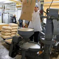 A long process: Rice is poured into a polishing machine. Searching Kyoto for the holy grail of Japanese rice vinegar