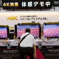 A man looks at Sony television sets in an electronics store in Tokyo on June 10. Sony, Panasonic cling to TVs, betting on halo effect of premium sets