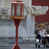 An elderly Chinese woman rests in a wheelchair at the Temple of Heaven park in Beijing on Friday. The number of senior tourists in China jumped by 58 percent last year compared to 2013, according to the state-run China Daily newspaper, and 62 percent of Chinese senior citizens join organized tours. Senior travel industry booms in graying China