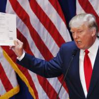 Real estate mogul Donald Trump, 69, displays his financial statement during his announcement that he will run for the 2016 presidential election at the Trump Tower in New York on Tuesday. Trump, one of America’s most flamboyant and outspoken billionaires, threw his hat into the race promising to make America great again. Trump blusters way into White House bid, blasts fellow Republicans, Obama, Mexicans, Saudis
