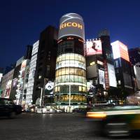 Taxis pass buildings illuminated at night in the Ginza district of Tokyo in May 2014. Tokyo court ruling says adultery OK if it's for business: experts
