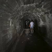 Journalists walk through underground tunnels that the Imperial Japanese Navy once used as secret headquarters underneath the Hiyoshi Campus of Keio University in Yokohama on Tuesday. Secret navy bunker in Yokohama gives a glimpse of WWII's final days