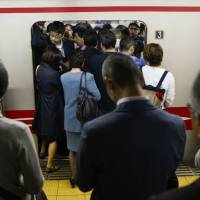 Passengers board a train on the Marunouchi Line, operated by Tokyo Metro Co., during morning rush hour at Tokyo's Shinjuku Station in May. Tokyo's heaving subway system girds for 2020 Olympics