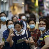 On guard: A mask-wearing visitor in Seoul asks a local for directions. Japan’s tabloid media have been inundated with coverage of MERS, or Middle East respiratory syndrome. Tabloids revel in South Korea's MERS misery