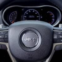 The logo of Jeep is seen on a steering wheel of the 2015 Jeep Grand Cherokee on a car dealership in New Jersey on July 24. Fiat Chrysler Automobiles could pay billions of dollars to buy back defective trucks as part of a settlement with U.S. safety regulators, but has the option to recover costs by reselling vehicles once they are repaired. In addition to the $105 million fine and vehicle buyback provision, FCA agreed to provide financial incentives to more than a million Jeep owners to bring their recalled vehicles in for repairs. Fiat Chrysler buy-back of unrepaired trucks may cost billions but it has resale option