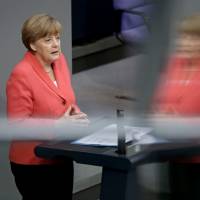 German Chancellor Angela Merkel gestures during her speech as part of a meeting of the German Bundestag in Berlin on Friday. Merkel asked German lawmakers to clear the way for negotiations on a new, third bailout package for Greece, arguing that it would be negligent not to try for a deal. Latest Greece rescue plan already in question even before it is finalized