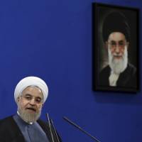 Iranian President Hassan Rouhani gives a news conference in Tehran on June 13, the second anniversary of his election. A picture of Supreme Leader Ayatollah Ali Khamenei hangs behind him. Nuclear deal could sharpen political tensions in Iran