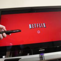 In this July 20, 2010, file photo, a person uses Netflix in Palo Alto, California. Netflix on Tuesday said it will expand into Japan beginning Sept. 2 to give the Internet video service its first presence in Asia. The firm said the same day it was offering up to a year of paid leave for child care. Netflix Japan debut set for Sept. 2 as service moves into Asia