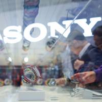 Visitors inspect a case of Sony SmartBand wearable devices on display at the Sony Corp. trade stand at the IFA consumer electronics show in Berlin in September last year. Seventy years on, the once-mighty Sony Corp. struggling for hits