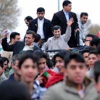 Iran’s then-president, Mahmoud Ahmadinejad (center), waves to well-wishers from his car during a public welcoming ceremony upon his arrival in the northwestern city of Tabriz, Iran, in November 2009. Iran's Ahmadinejad eyeing political comeback