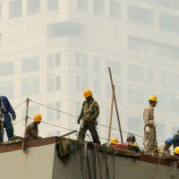 Laborers work on a smoggy June day in Beijing. A new study shows that air pollution is killing about 4,000 people in China a day, accounting for 1 in 6 premature deaths in the world’s most populous country. U.S. study puts China air pollution deaths at 4,000 a day; particulates particularly faulted