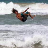 Rio Batan Matienzo takes a leap while skim boarding as Tropical Storm Erika approaches the island in Luquillo, Puerto Rico, Thursday. Erika pummeled the eastern Caribbean island of Dominica, unleashing landslides and killing at least four people. The storm knocked out power and water supplies and had dumped 15 inches of rain on Dominica by early Thursday, according to the weather service in the nearby island of Antigua. Erika churning toward hurricane status, Florida; four dead in Dominica, 20 missing