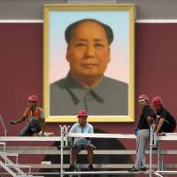 Workers install temporary seating at Tiananmen Square near the large portrait of Chairman Mao Zedong on Tiananmen Gate in Beijing, Friday. A war-related film coming out in China is drawing online fire for falsely portraying Mao as having played a role in an Allied conference in Cairo to map out postwar Asia. Chinese film draws online critics for distorting history with bogus Mao spin