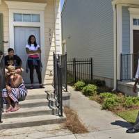 Residents watch as U.S. President Barack Obama walks during a tour of the Treme neighborhood Thursday in New Orleans. Obama visited New Orleans Thursday to praise its people's extraordinary resilience, 10 years after Hurricane Katrina ravaged the Big Easy and shattered Americans' confidence in government. Decade after Katrina, Obama praises New Orleans 'resilience' from natural, man-made disasters