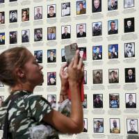 A woman looks at a wall of portraits of Ukrainian servicemen killed a year ago during fighting with pro-Russian rebels near the town of Ilovaysk in eastern Ukraine during a commemoration ceremony in Kiev on Saturday. Ukraine's parliament backs draft law giving east special status