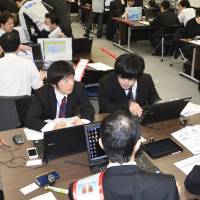 Government ministry and agency staff take part in a March training session on fighting cyberattacks in Tokyo. Filling the ranks of Japan's cyberwarriors in time for 2020 Olympics proves a major challenge