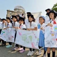 Children holding peace messages gather in Peace Memorial Park in Hiroshima on Sunday ahead of the annual memorial ceremony marking the 70th anniversary of the U.S. atomic bombing. Hiroshima 70th A-bomb anniversary will draw officials from record 100 countries