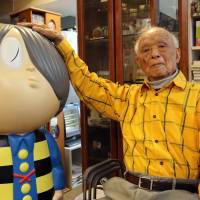 Comic artist Shigeru Mizuki, 93, shows his famous character “Kitaro” at his studio in Tokyo in May. Mizuki uses manga to spread his message of the horror of war. WWII veterans serve new mission warning of the horror of war