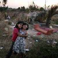 Living in poverty: Migrant children pose in front of makeshift shelters on the Greek Aegean island of Kos on Aug. 16. Scans reveal how poverty hurts children's brains