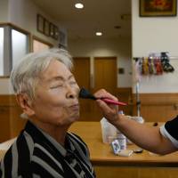 Boom and bust: A worker applies make up to an elderly resident at a care facility in Osaka. Japan is grasping for ways to satisfy the increasing need for such facilities as postwar baby boomers hit old age Japan's elderly boomers squeezed to pay more as care facilities struggle