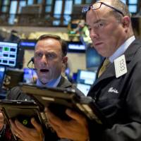 Traders work on the floor of the New York Stock Exchange Tuesday. Post-Labor Day Wall St. rockets jumps 2% amid China stimulus hopes