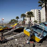 Fishing boats run aground by the sea line the beach Thursday in Coquimbo, some 445 km north of Santiago, after being hit by tsunami after Wednesday’s quake off Chile. Japan is bracing for tsunami to reach its Pacific shores early Friday. Tsunami of 80 cm strikes Japan after Chile quake; alert lifted