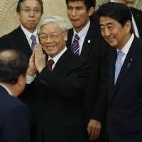 Vietnamese Communist Party General Secretary Nguyen Phu Trong, escorted by Prime Minister Shinzo Abe, greets a guest as they arrive for a formal dinner at Abe's official residence in Tokyo on Tuesday. Abe pledges more ships to Vietnam's top leader to offset China
