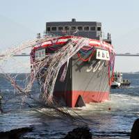 The Maritime Self-Defense Force's newest minesweeper, the Awaji, is launched at Japan Marine United Corp.'s Tsurumi yard in Yokohama on Tuesday. Anticipating more muscular missions, MSDF launches new minesweeper