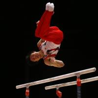 Kohei Uchimura performs on the parallel bars at the World Artistic Gymnastics Championships on Sunday in Glasgow, Scotland. Japan men's gymnasts top team qualification
