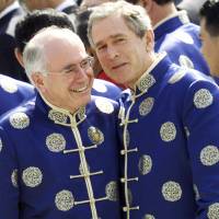 Australian Prime Minister John Howard and U.S. President George W. Bush wear traditional Chinese jackets as they chat during a group photo session at the APEC summit in Shanghai in October 2001. Shirt photos offer sometimes awkward moments of APEC unity