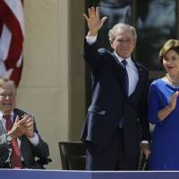 Former President George H.W. Bush applauds with Laura Bush after former President George W. Bush’s speech during the 2013 dedication of the George W. Bush Presidential Center in Dallas. Elder Bush in new biography blasts 'hard-line' Cheney, 'iron-ass' Rumsfeld for serving son badly
