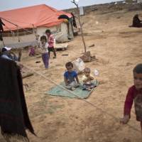 Syrian refugee children play Oct. 23 outside their tents at an informal tented settlement near the Syrian border on the outskirts of Mafraq, Jordan. Bold ideas for helping Syrian refugees and their overburdened Middle Eastern host countries are gaining traction among international donors who were shocked into action by this year’s migration of hundreds of thousands of desperate Syrians to Europe, but U.S. Republican lawmakers want to curb any influx, citing security worries. Post-Paris shutdown showdown: Republicans try to block Syrian refugee funds