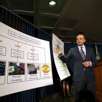 Preet Bharara, U.S. Attorney for the Southern District of New York, speaks next to a chart during a news conference New York Tuesday. U.S. prosecutors on Tuesday unveiled criminal charges accusing three men of helping run a sprawling series of hacking and fraud schemes, including a huge 2014 attack against JPMorgan Chase Four charged in hack of data on millions of JPMorgan Chase, other customers